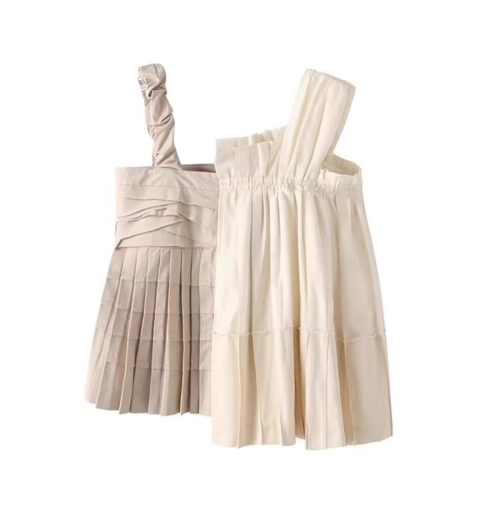 Blusa asimétrica en tonos neutros con detalles de plisados y tirantes únicos, ideal para un look moderno y sofisticado.