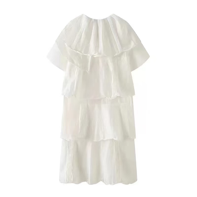 Vestido blanco con capas y detalles plisados en la parte inferior, ideal para un look fresco y elegante.